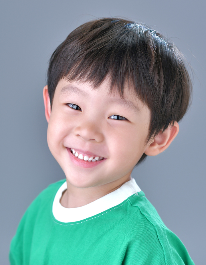 옆으로 돌아앉아 카메라를 바라보며 환하게웃고있는 어린이 일반증명사진