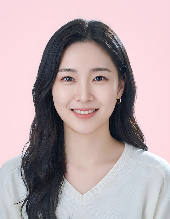 분홍색 배경에서 흰색 브이넥 상의를 입은 여성의 증명사진. 자연스럽게 내려오는 긴 웨이브 헤어스타일과 밝은 미소로 화사하고 친근한 인상을 표현한 사진.